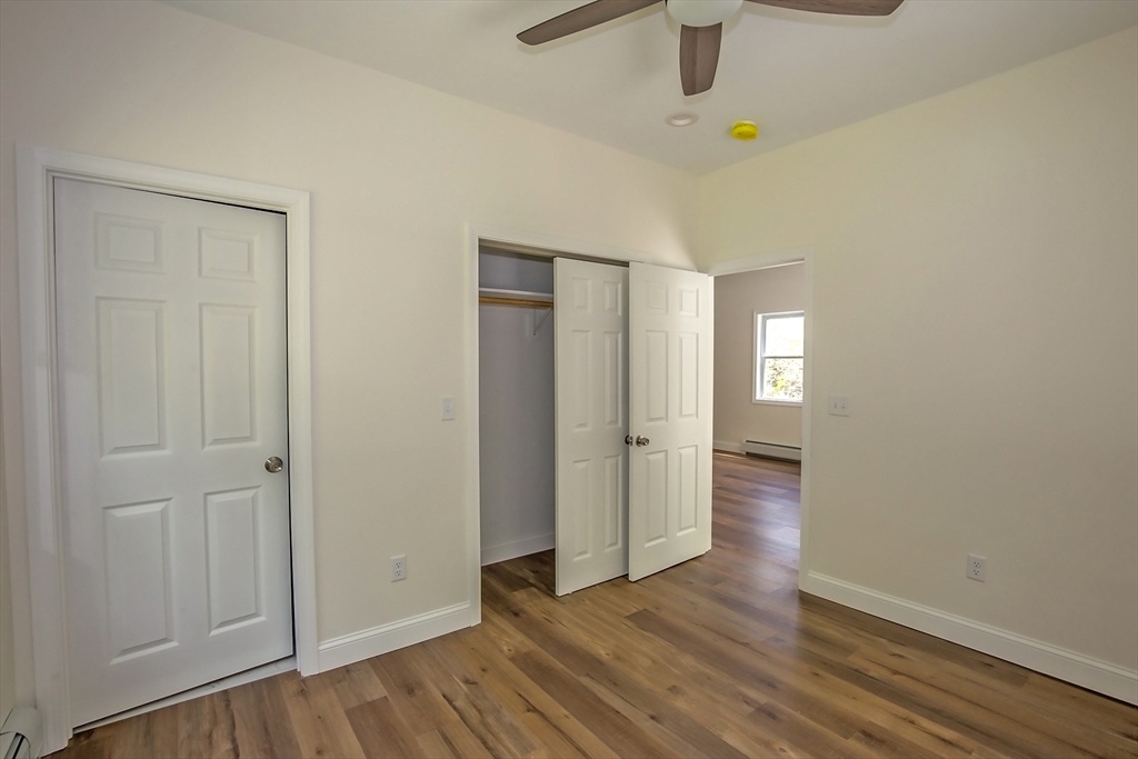 165 Sandisfield Road Sandisfield, MA 01255 - Photo 21 of 37 an empty room with wooden floor cabinet and windows