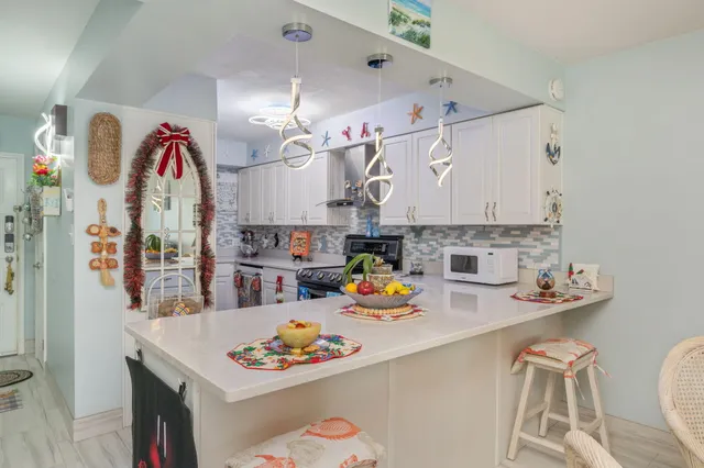 a kitchen with a sink a stove and chairs