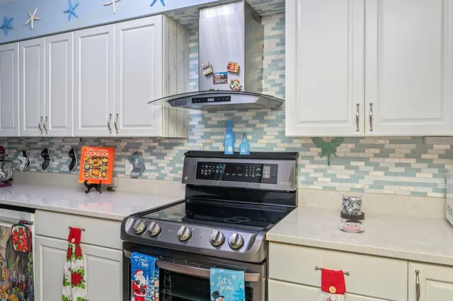 a kitchen with stainless steel appliances granite countertop a stove and white cabinets