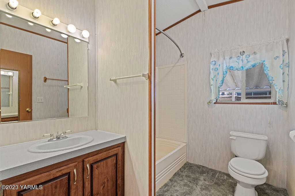 1200 South Euclid Road, Unit 99 Grandview, WA 98930 - Photo 17 of 22 a bathroom with a granite countertop sink a toilet and a shower