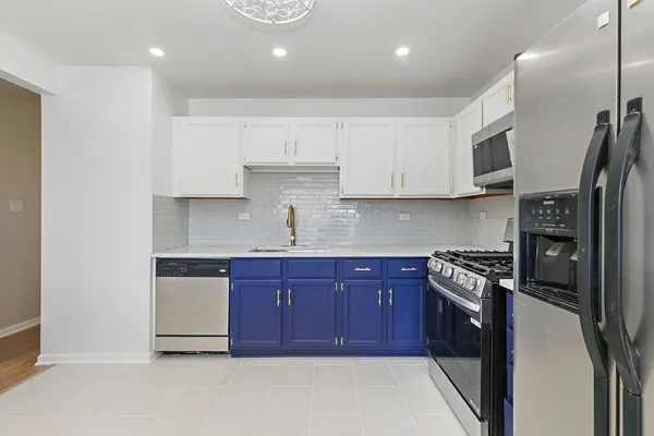 a kitchen with stainless steel appliances granite countertop a stove a sink and a refrigerator