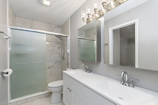 a bathroom with a sink a toilet and shower