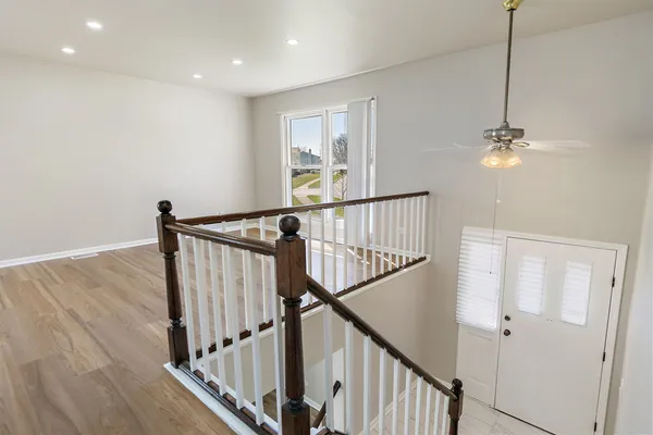 a view of a hallway with wooden floor and stairs