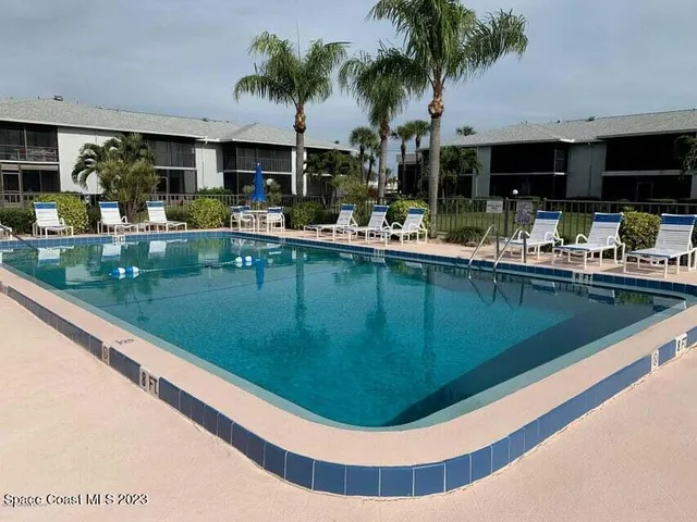 a view of a big yard with large plants and wooden fence