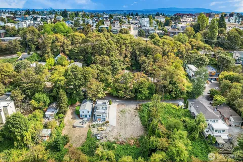an aerial view of residential houses with outdoor space and trees