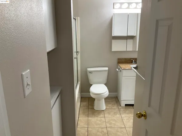a white toilet sitting next to a bathroom sink and vanity
