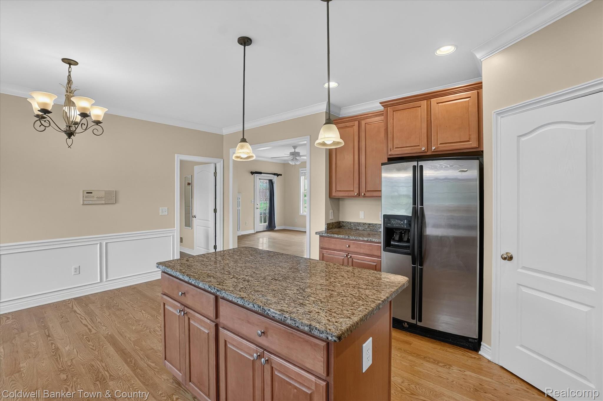 1725 Town Commons Drive Howell, MI 48855 - Photo 16 of 53 Kitchen featuring a central island with granite countertop, wood-finish cabinetry, stainless steel refrigerator, and pendant lighting