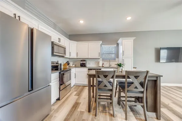 a kitchen with cabinets and chairs