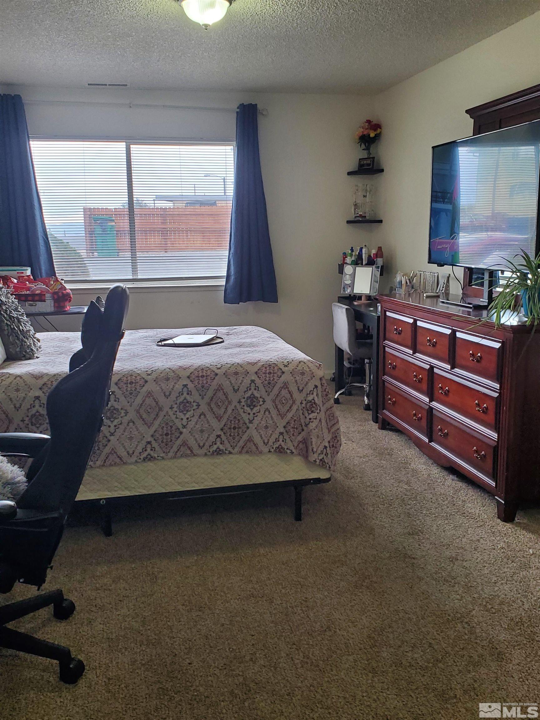 3575 Gypsum Road Reno, NV 89503 - Photo 12 of 32 a bedroom with a bed and large windows