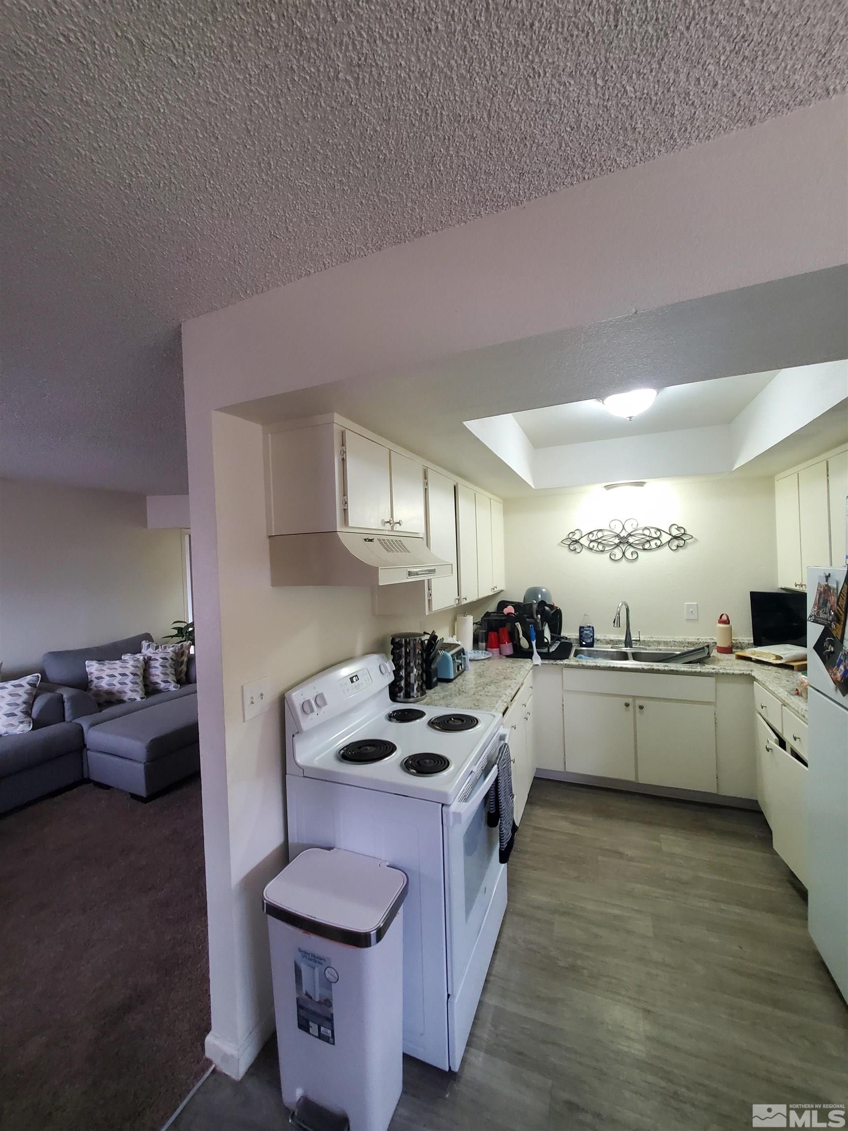 3575 Gypsum Road Reno, NV 89503 - Photo 15 of 32 a kitchen with a stove cabinets and wooden floor