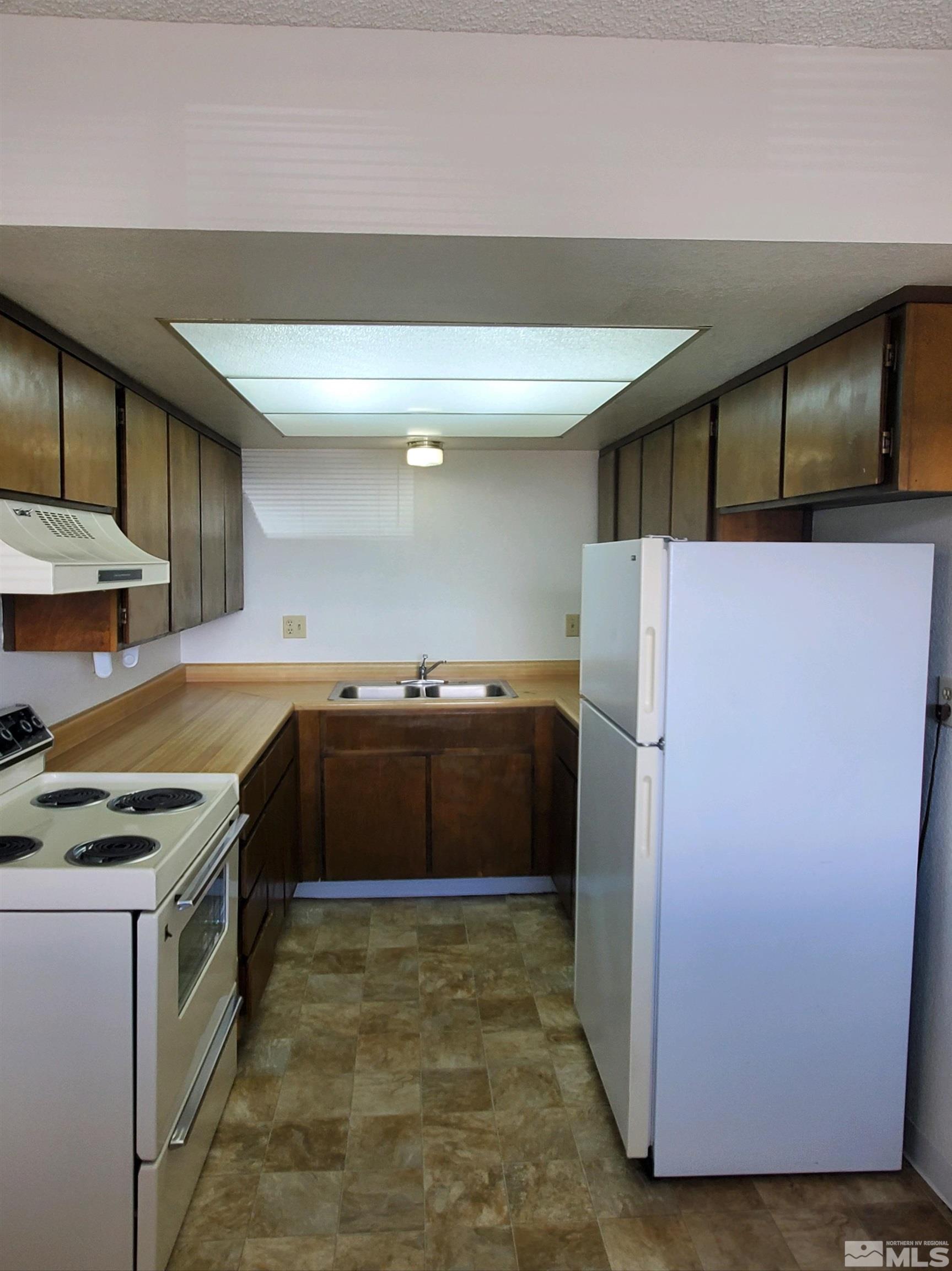 3575 Gypsum Road Reno, NV 89503 - Photo 21 of 32 a kitchen with a refrigerator and a sink
