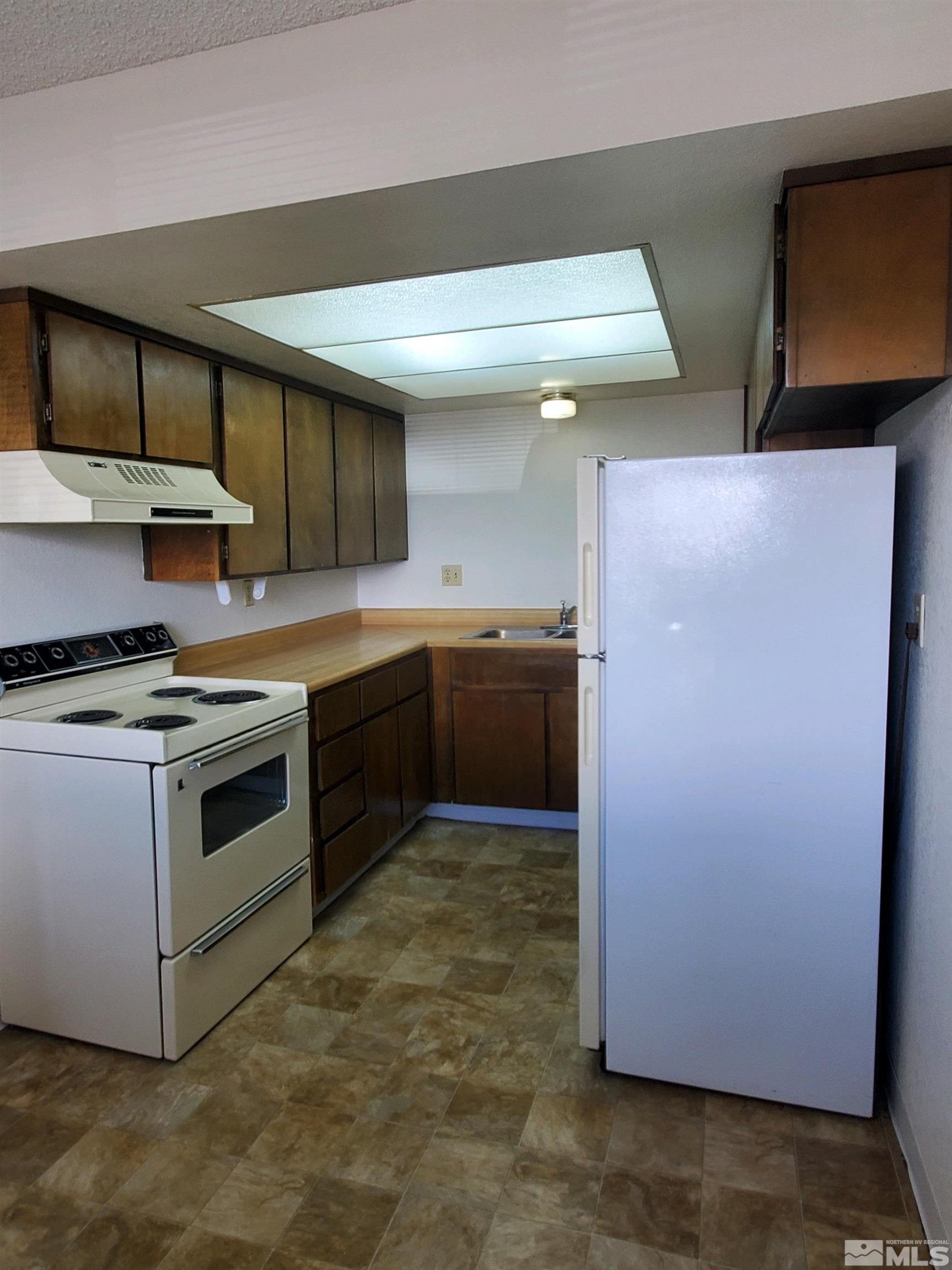 3575 Gypsum Road Reno, NV 89503 - Photo 22 of 32 a kitchen with stainless steel appliances granite countertop a stove a sink and a refrigerator