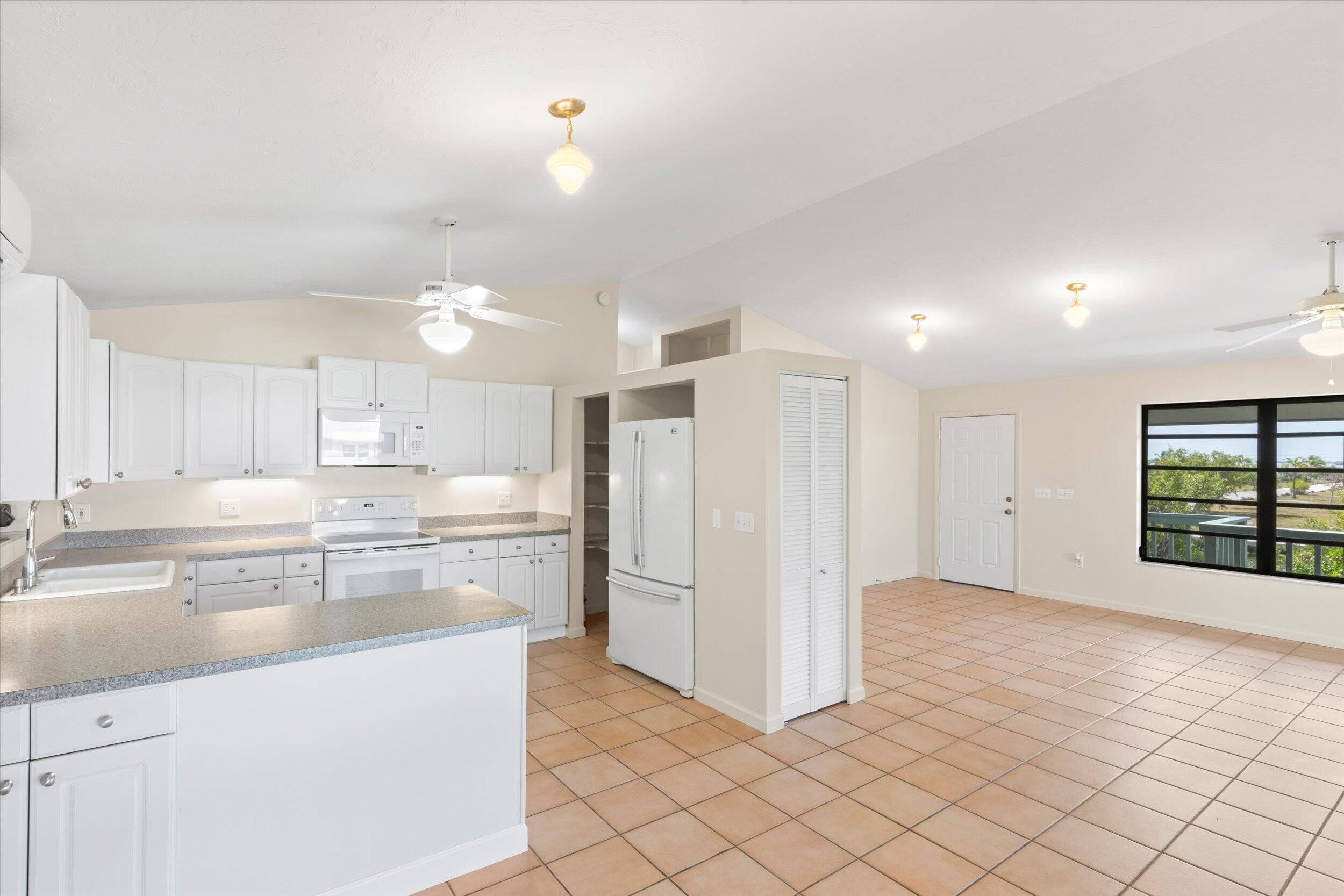 3714 Pine Street Big Pine Key, FL 33043 - Photo 13 of 64 a kitchen with stainless steel appliances a refrigerator and white cabinets