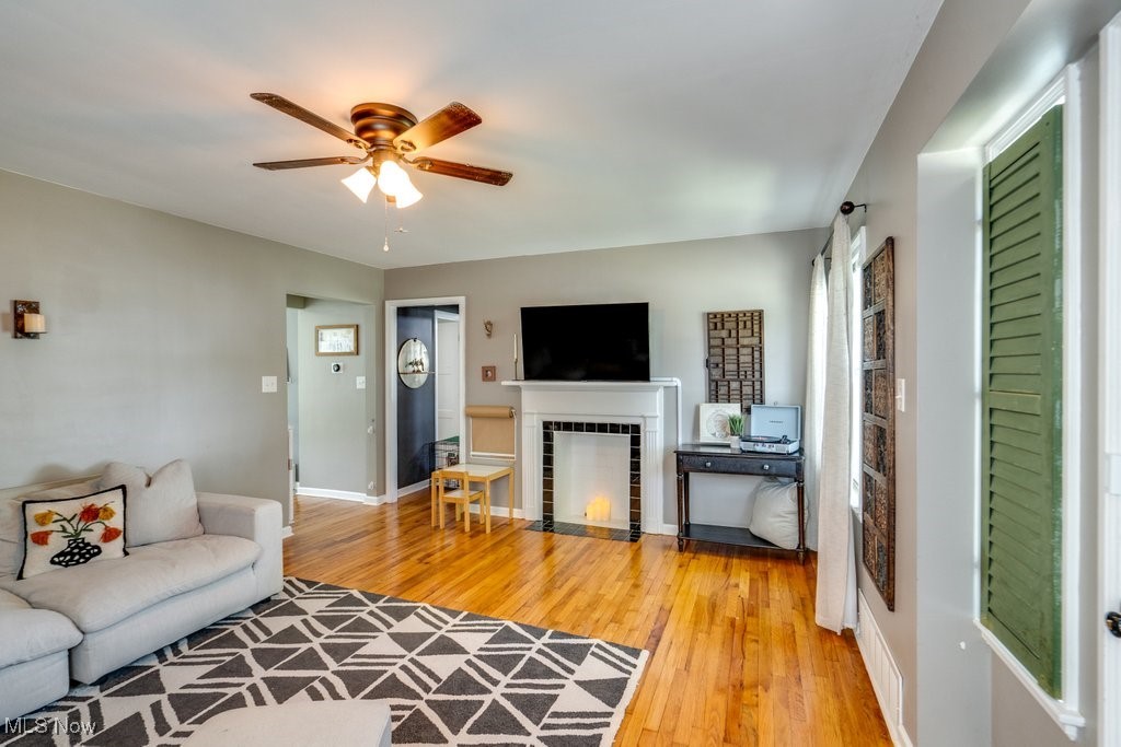 5284 Bridgewater Road Cleveland, OH 44124 - Photo 3 of 22 Living room with a tile fireplace, light hardwood / wood-style flooring, and ceiling fan