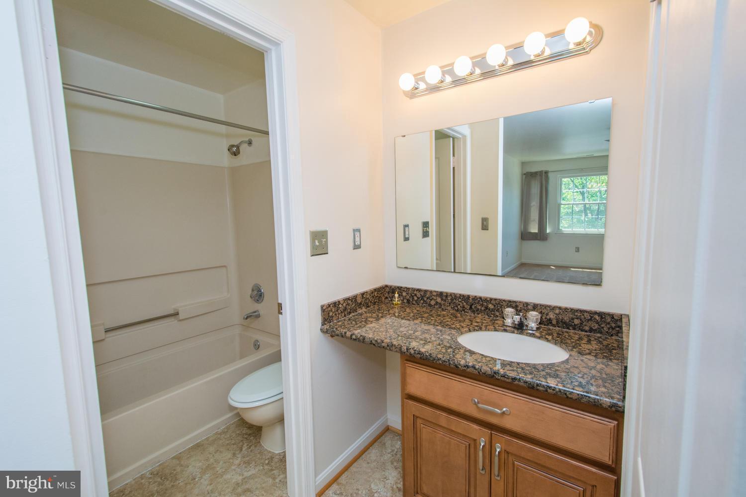 8335 Montgomery Run Road, Unit H Ellicott City, MD 21043 - Photo 14 of 22 a bathroom with a granite countertop sink toilet and shower