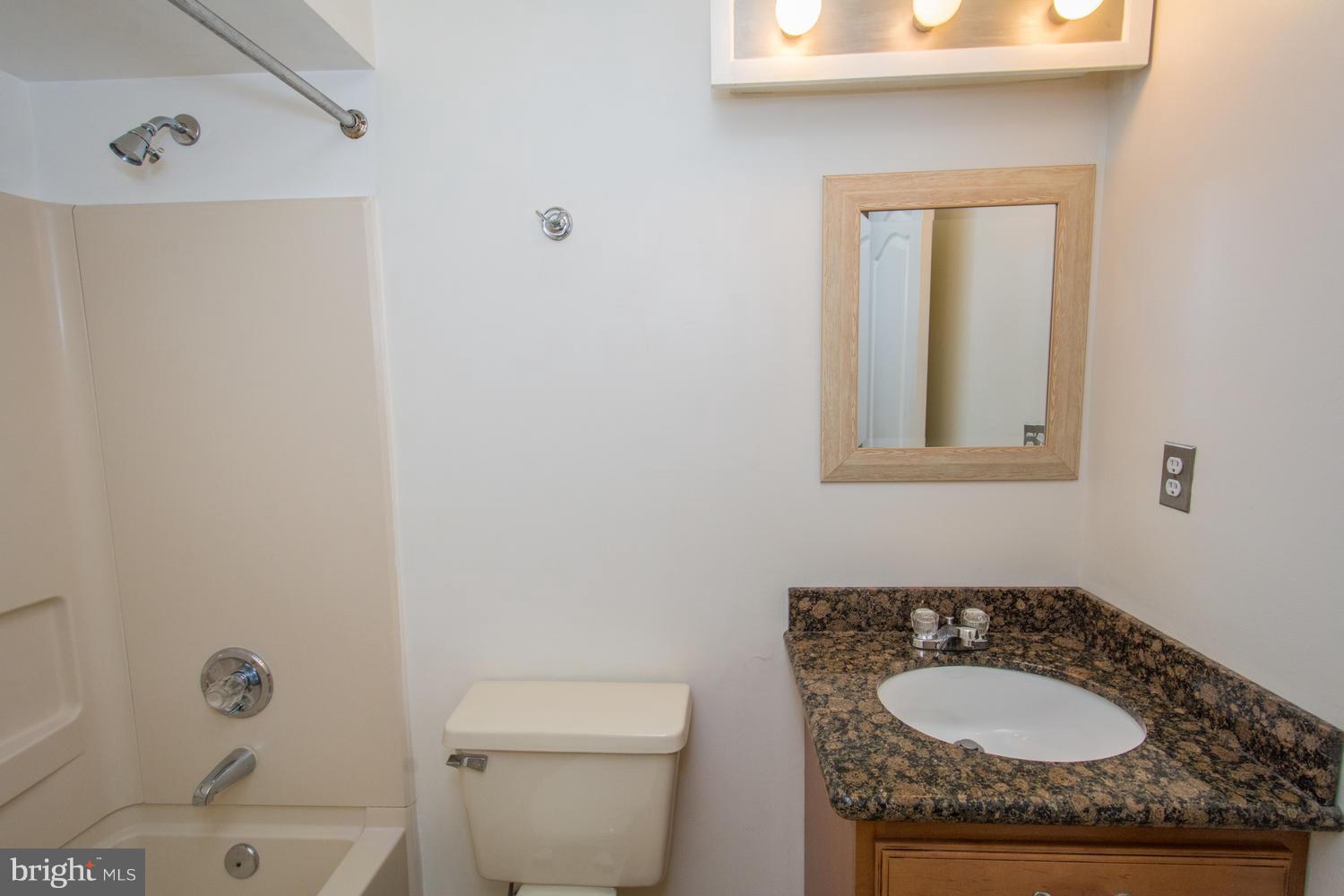 8335 Montgomery Run Road, Unit H Ellicott City, MD 21043 - Photo 18 of 22 a bathroom with a granite countertop sink toilet and mirror
