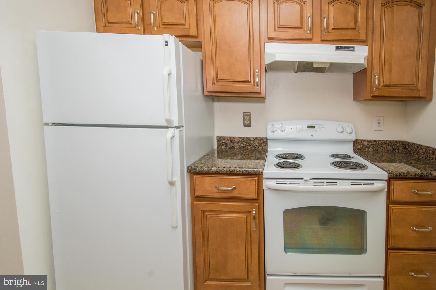 8335 Montgomery Run Road, Unit H Ellicott City, MD 21043 - Photo 3 of 22 a white refrigerator freezer and a stove sitting inside of a kitchen