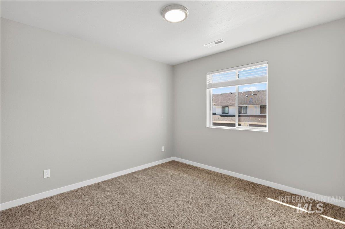 2505 East Goldstone Street Meridian, ID 83642 - Photo 12 of 28 Room featuring neutral gray walls, brown carpet flooring, and white baseboards