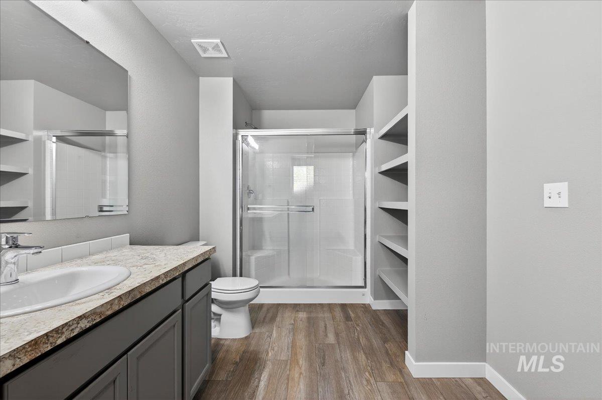 2505 East Goldstone Street Meridian, ID 83642 - Photo 17 of 28 Modern bathroom featuring a single vanity with a white basin, light-toned countertop, and dark cabinetry