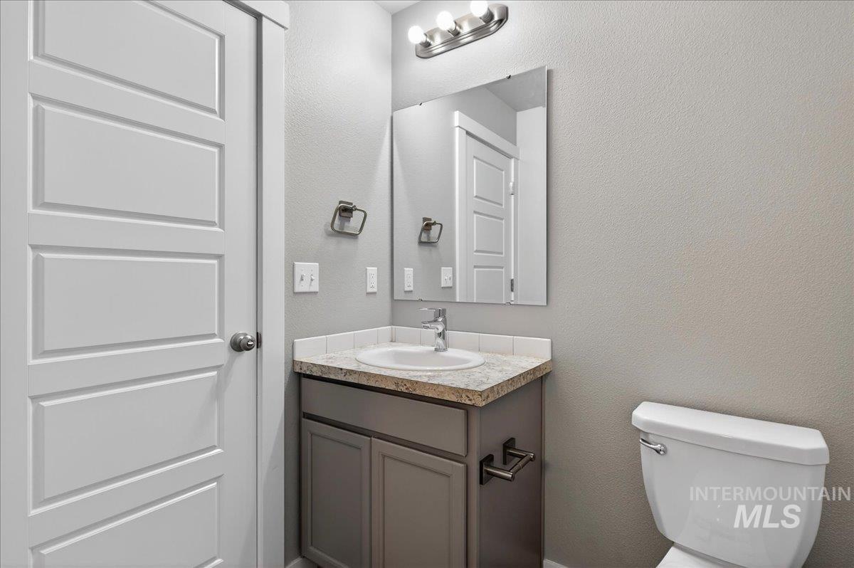 2505 East Goldstone Street Meridian, ID 83642 - Photo 19 of 28 Modern bathroom vanity with a granite-style countertop, undermount sink, and brushed nickel faucet
