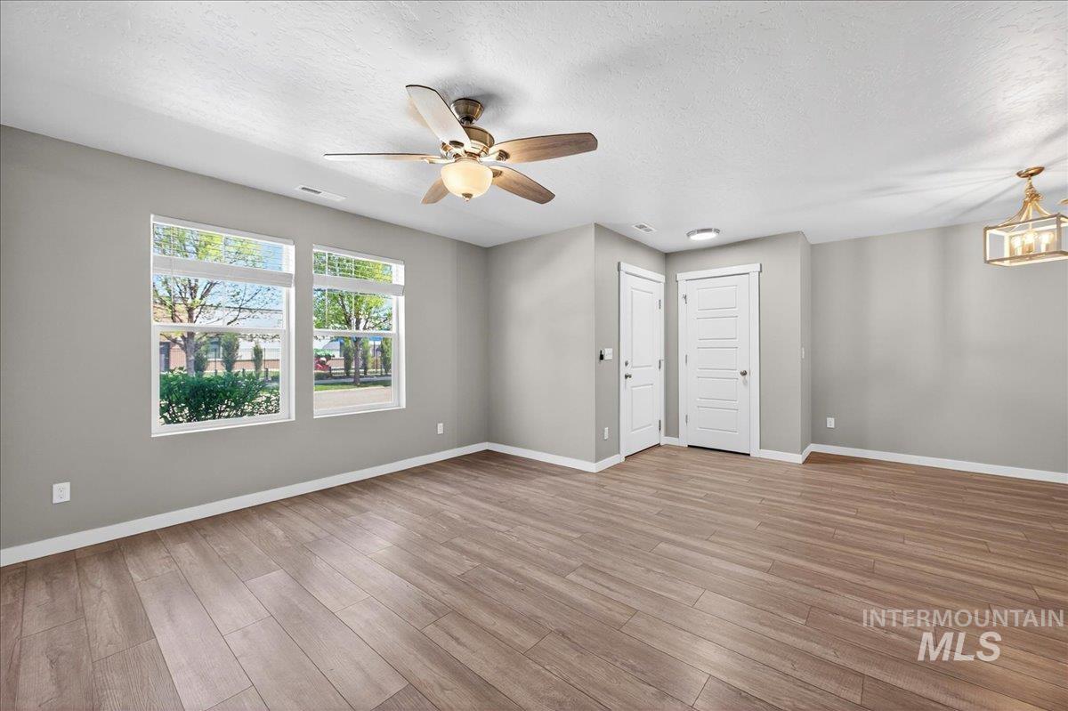2505 East Goldstone Street Meridian, ID 83642 - Photo 2 of 28 Spacious room featuring wood-finish flooring, light grey wall tones, and white trim