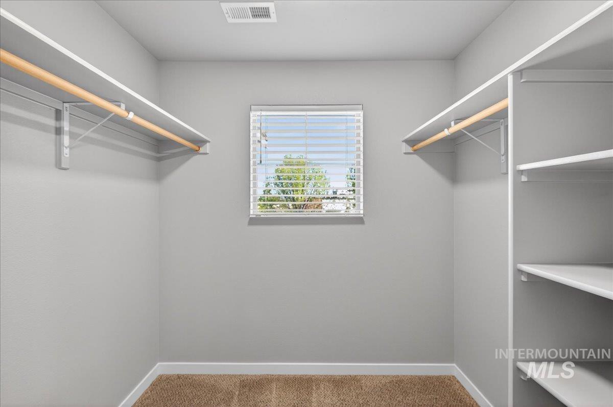2505 East Goldstone Street Meridian, ID 83642 - Photo 22 of 28 Walk-in closet with carpet flooring, a window featuring blinds, and integrated shelving and hanging rods