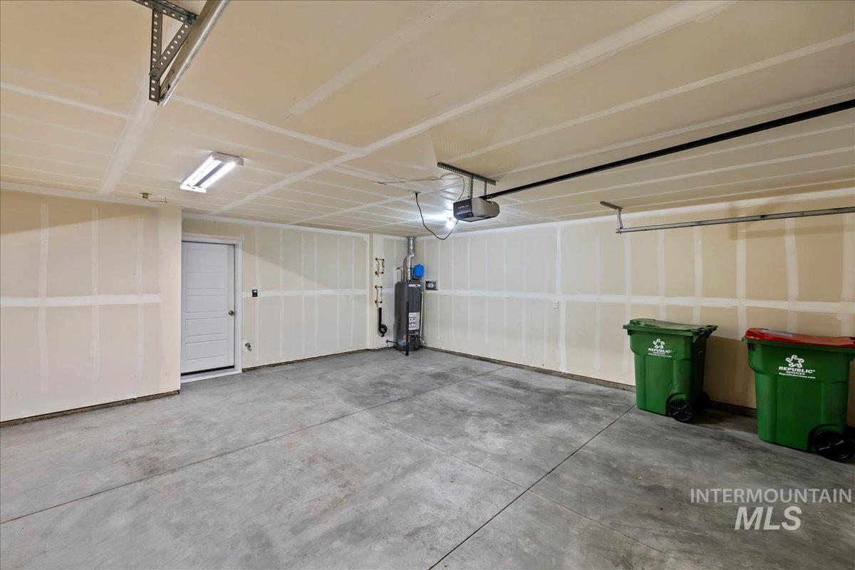 2505 East Goldstone Street Meridian, ID 83642 - Photo 23 of 28 Spacious garage with a concrete floor, overhead fluorescent lighting, and an interior access door