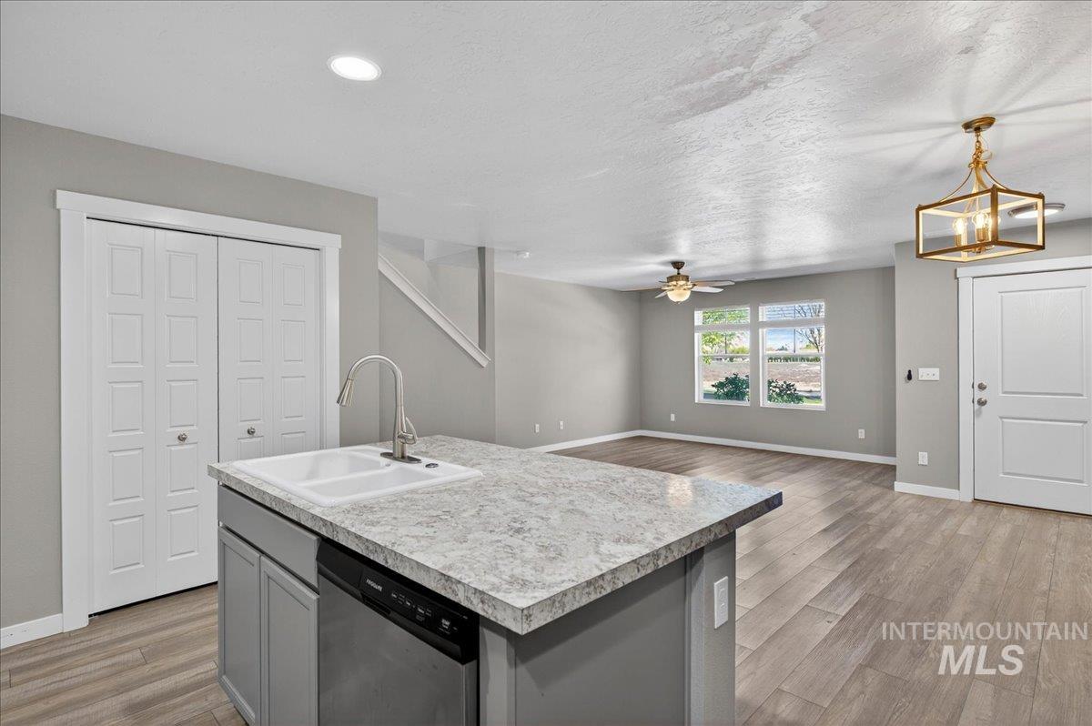 2505 East Goldstone Street Meridian, ID 83642 - Photo 10 of 28 Kitchen island featuring an undermount sink, gooseneck faucet, and integrated dishwasher