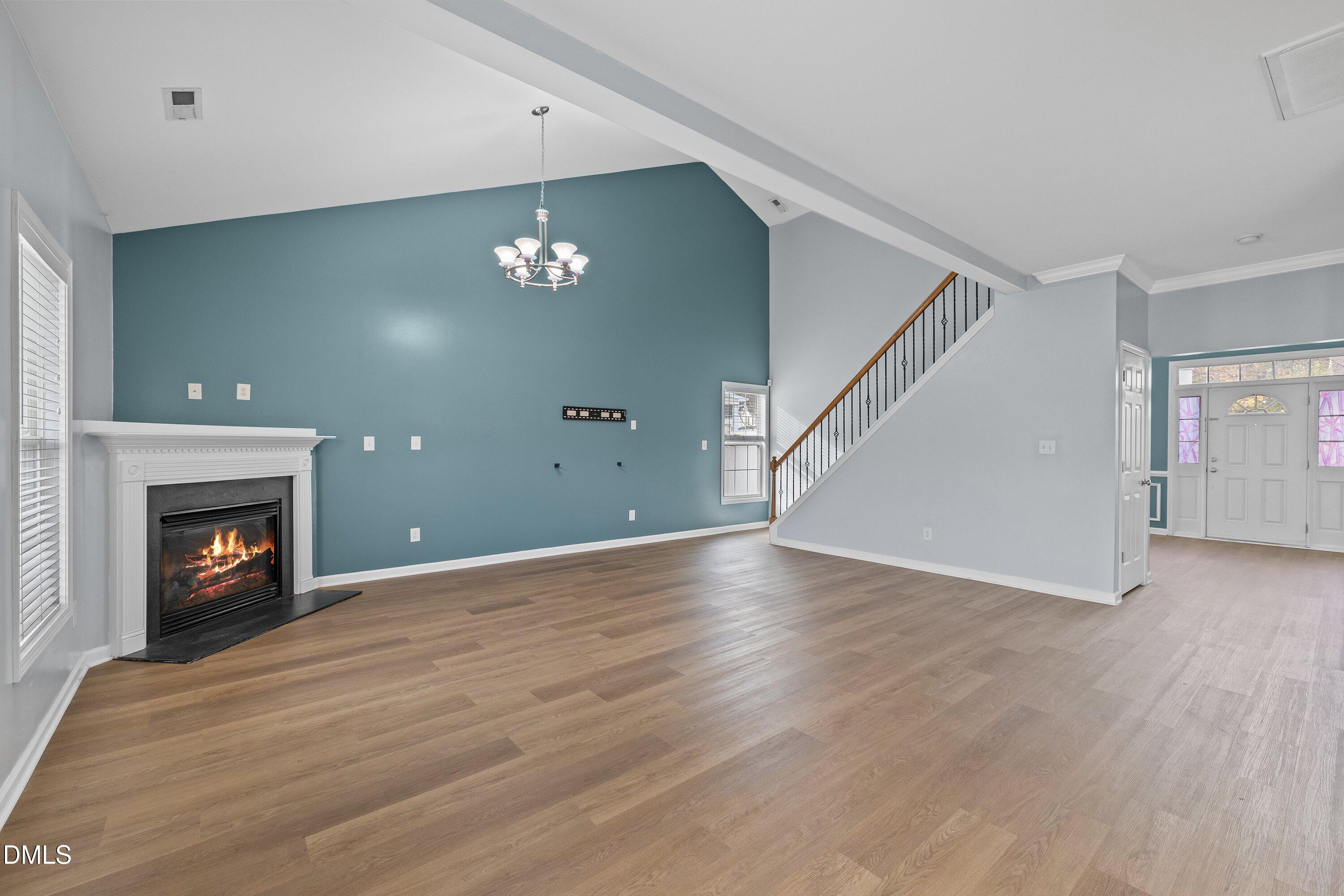 508 Arbor Crest Road Holly Springs, NC 27540 - Photo 11 of 45 an empty room with wooden floor fireplace and windows