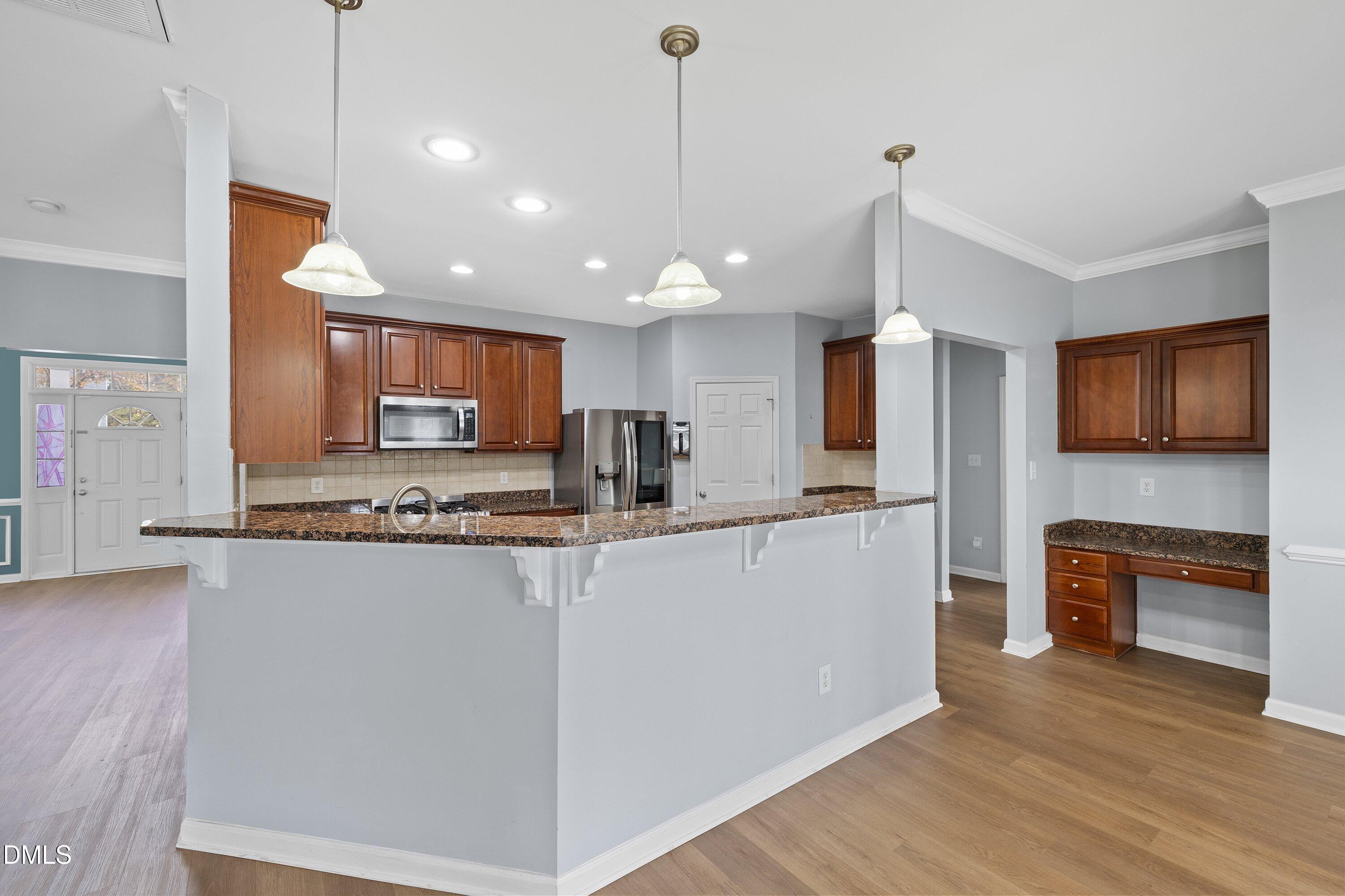508 Arbor Crest Road Holly Springs, NC 27540 - Photo 15 of 45 a view of a kitchen with kitchen island a counter top space a sink stainless steel appliances and cabinets