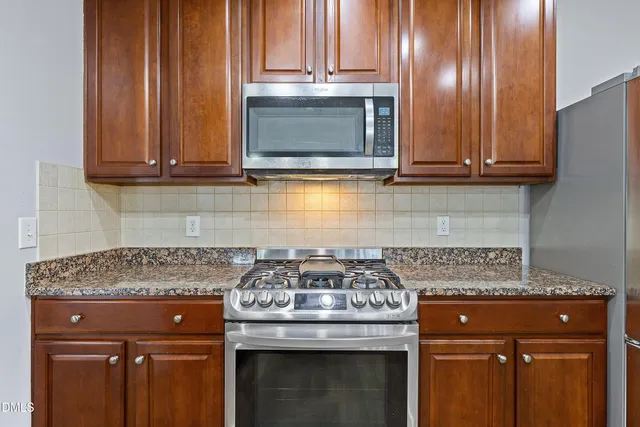 a view of a kitchen with granite countertop cabinets and a stove top oven