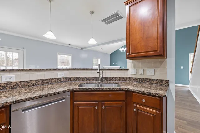 a kitchen with granite countertop a sink and cabinets