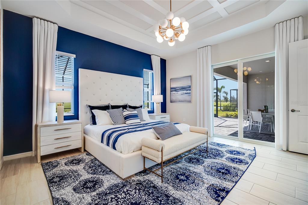 7165 Inlet Isles Lakewood Ranch, FL 34202 - Photo 15 of 26 a bedroom with a large bed and a chandelier