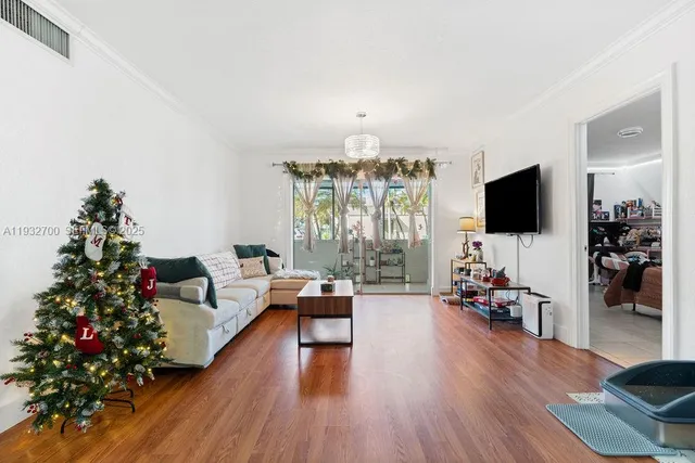 a living room with furniture flat screen tv and wooden floor