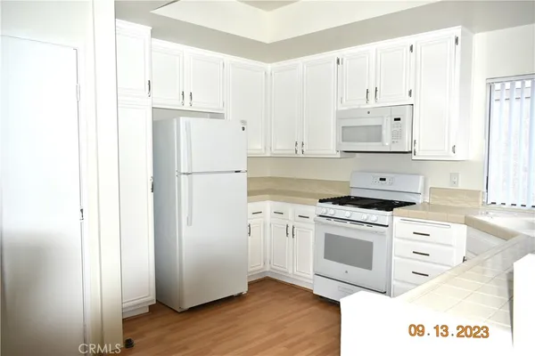 a kitchen with cabinets appliances and a window