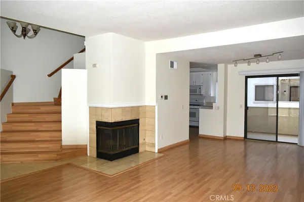 a view of a livingroom with wooden floor and a fireplace
