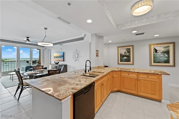a kitchen with stainless steel appliances granite countertop a stove top oven a sink dishwasher and a refrigerator