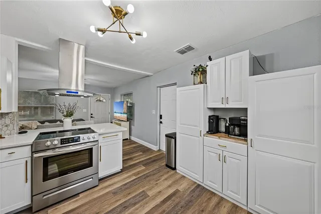 a kitchen with white cabinets and appliances