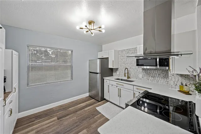 a kitchen with stainless steel appliances a sink stove and refrigerator