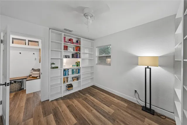 a view of empty room with wooden floor and window