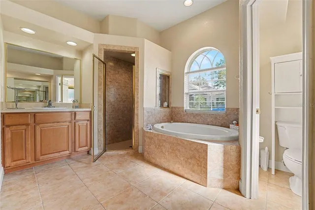 a spacious bathroom with a tub sink and mirror