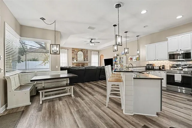 a kitchen with stainless steel appliances kitchen island granite countertop a stove a sink and a refrigerator