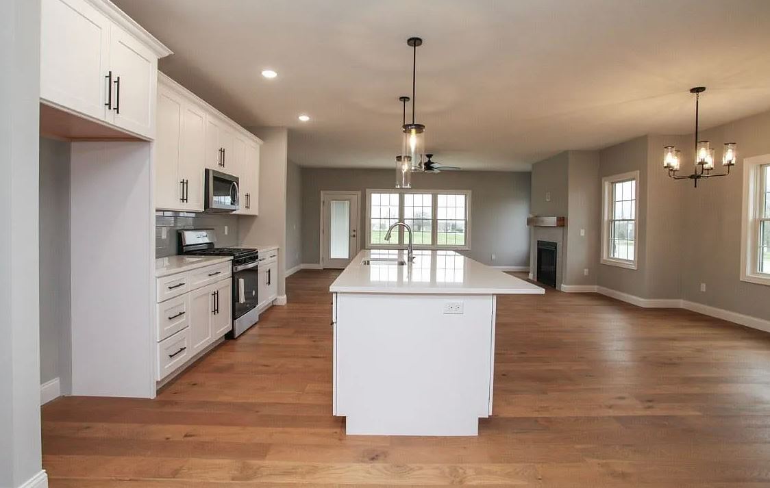 1 Saint Ivans Circle Bloomington, IL 61705 - Photo 7 of 29 a large kitchen with kitchen island a stove a sink a center island and wooden floor