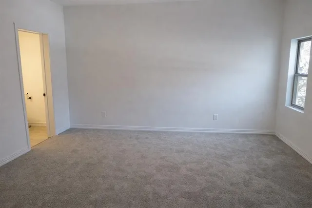 an empty room with windows and closet