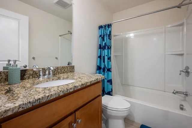 a bathroom with a granite countertop sink toilet and shower