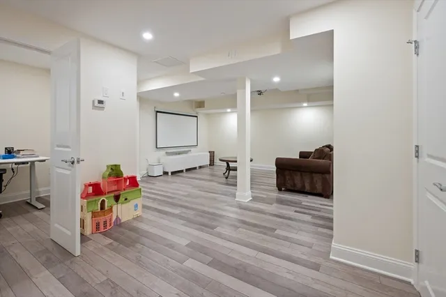 a living room with furniture stairs and a wooden floor