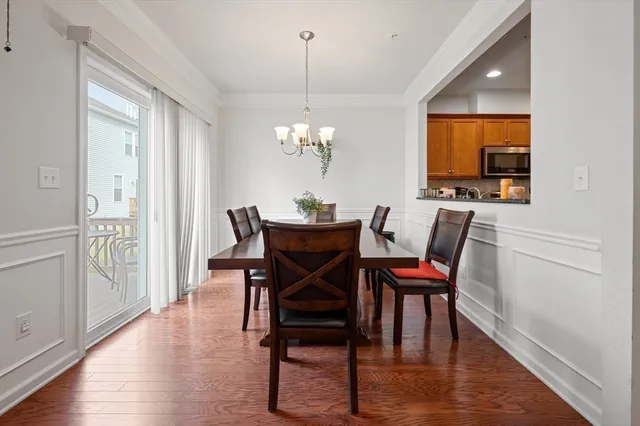 a dining room with furniture a chandelier and wooden floor