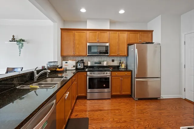 a kitchen with granite countertop a refrigerator and a stove