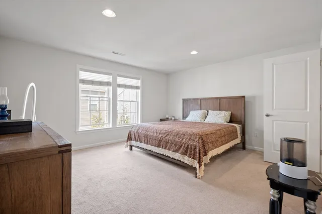 a bed sitting in a spacious bedroom next to a window