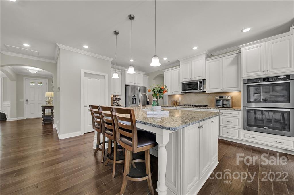 207 Kingsdown Avenue Charlotte, NC 28270 - Photo 13 of 48 a kitchen with stainless steel appliances granite countertop a kitchen island a stove a sink a dining table and chairs